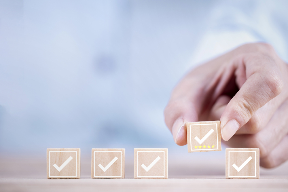 Hand putting checked blocks in place - AI needs strict governance policies in place to effectively manage risks