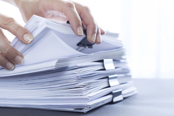 Hands going through a stack of documents - someone who knows the code