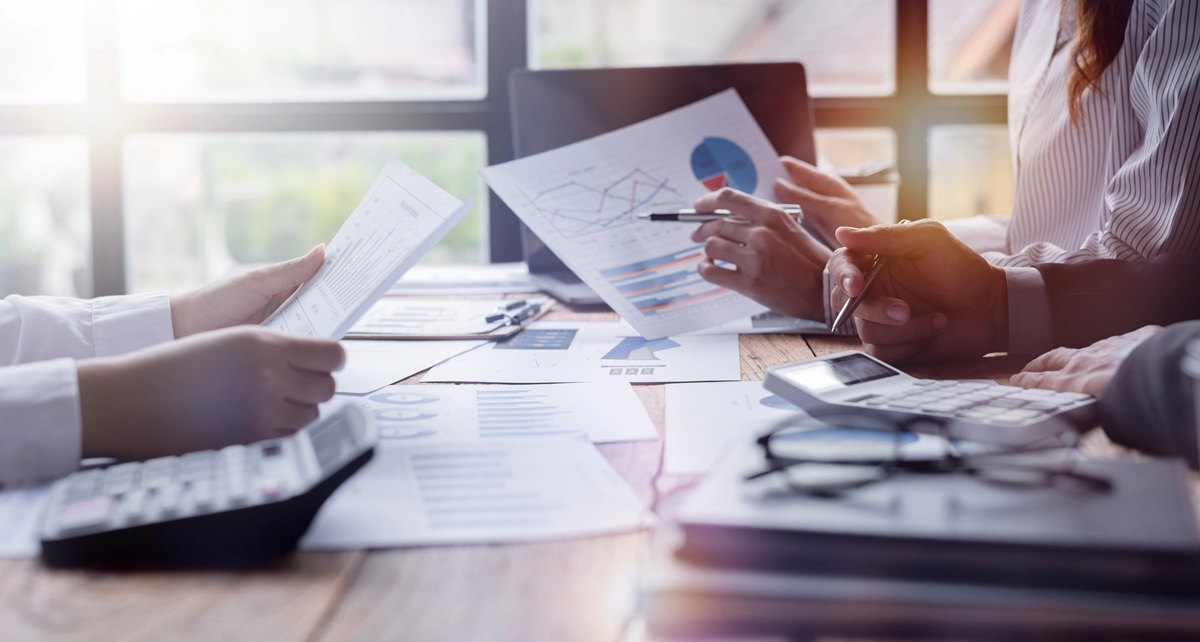 Image of people at a table reviewing data and presentations