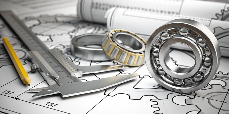 Image of engineering articles such as gears, compass, pen, and blueprints