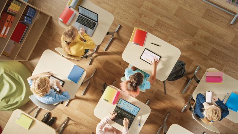 overhead view of children in an elementary school sitting at their desks working